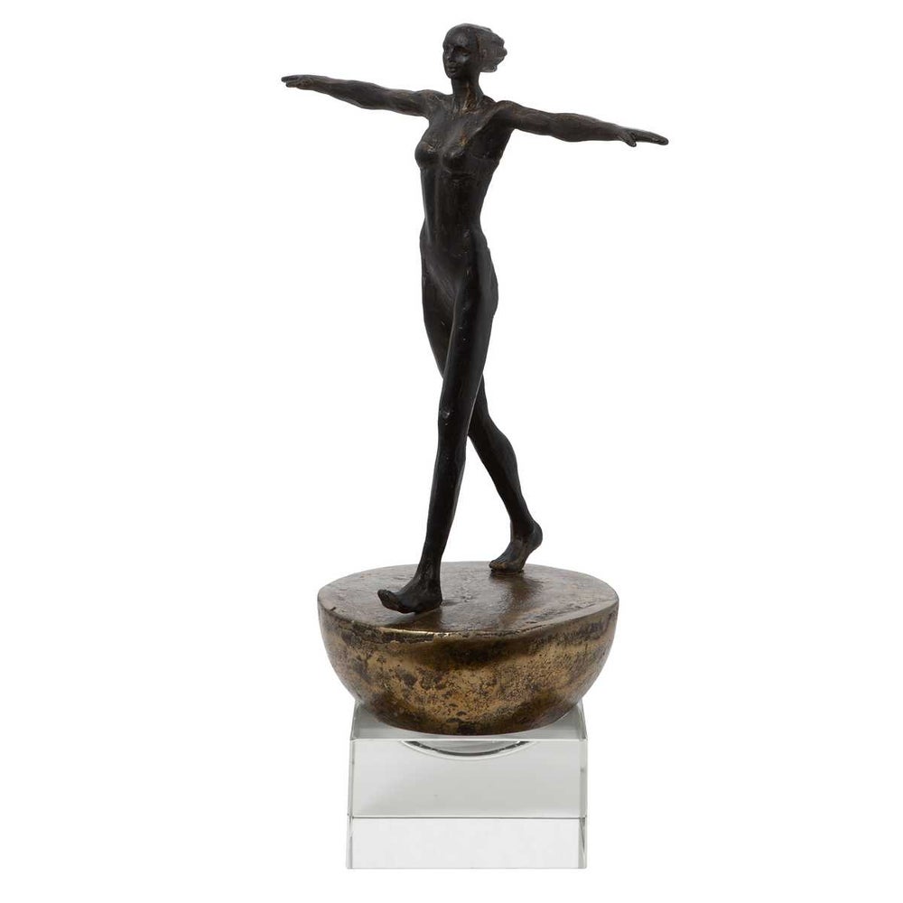 Woman Finding Balance sculpture, walking upright on the base with arms straight out to the sides.